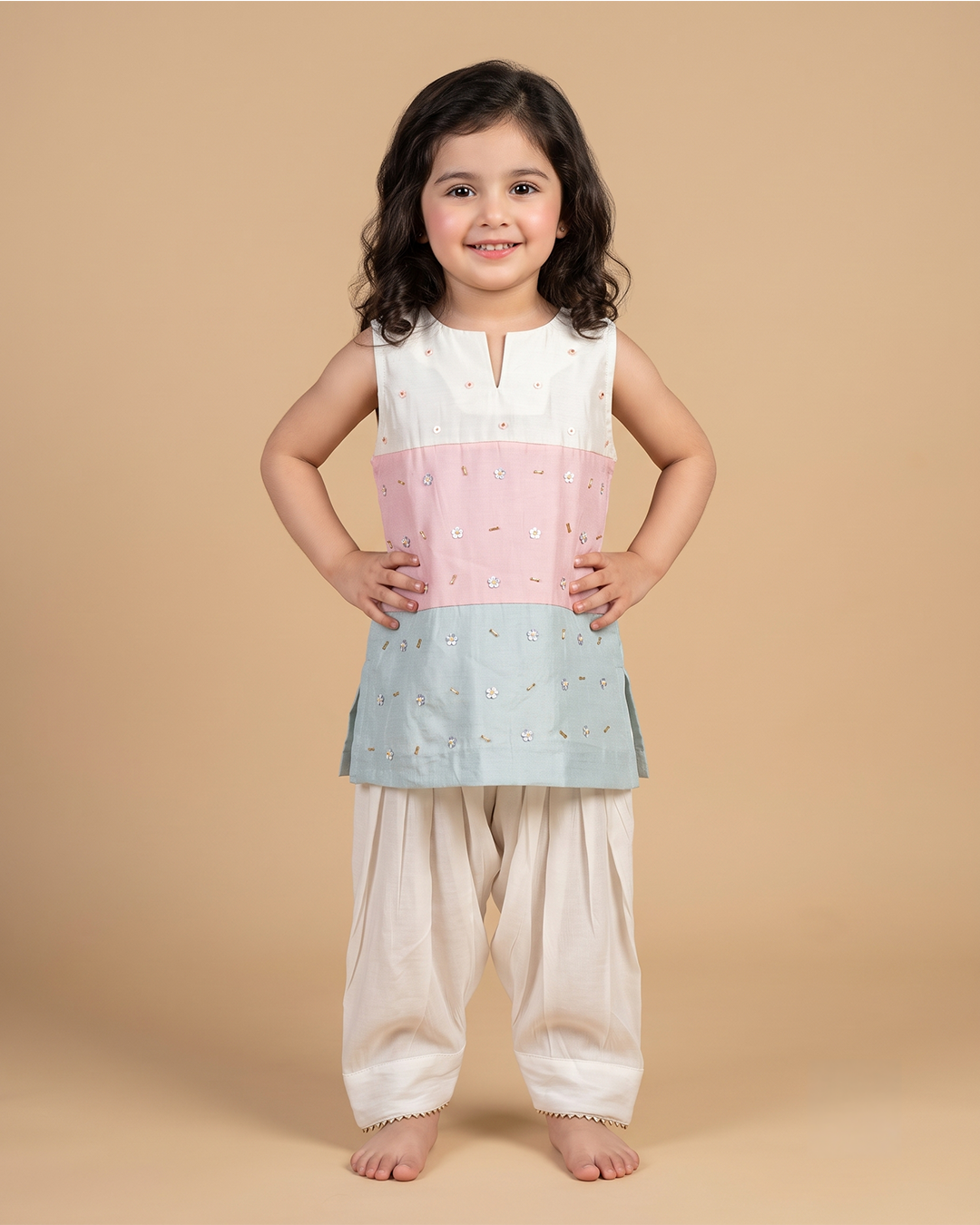 Girl wearing a pastel chanderi embroidered sleeveless kurta with ivory dhoti pants for festive occasions