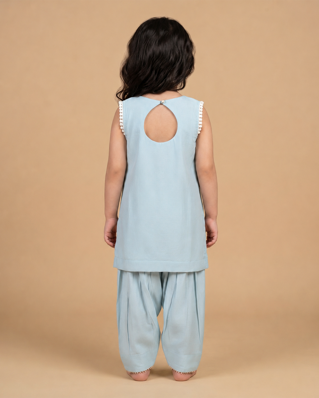 Girl wearing a pastel chanderi peplum kurta with floral embroidery and matching dhoti pants for festive occasions