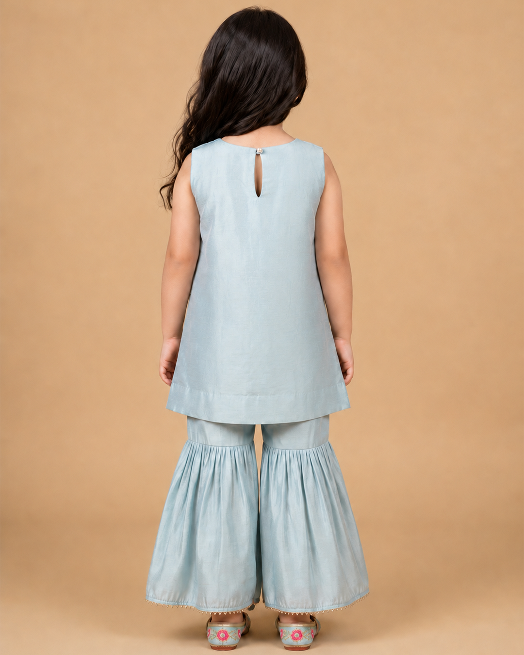 Girl wearing a sky blue Chanderi embroidered sleeveless kurta with matching flared sharara pants