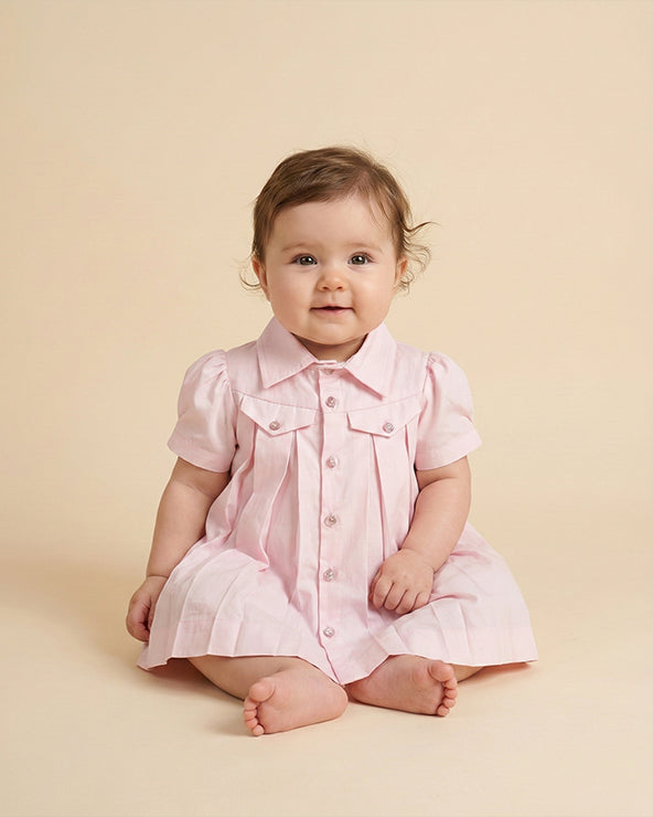Baby pink paper poplin dress for infants with pleated detailing and shirt style yoke