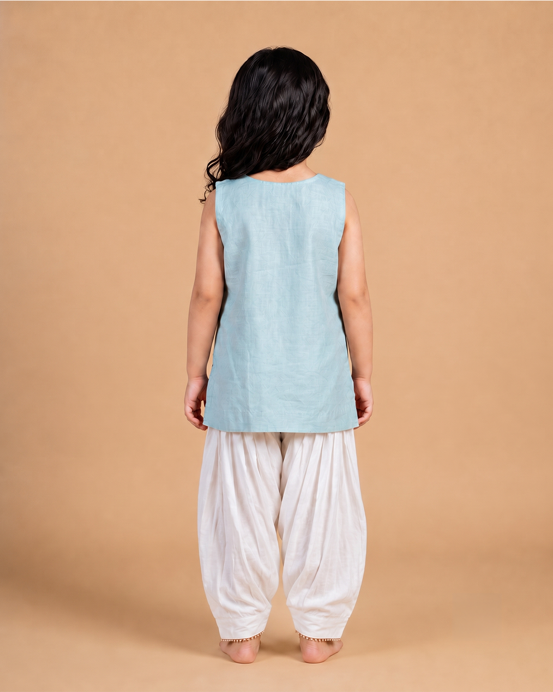 Girl wearing a pastel Chanderi embroidered sleeveless kurta with ivory dhoti pants for festive occasions