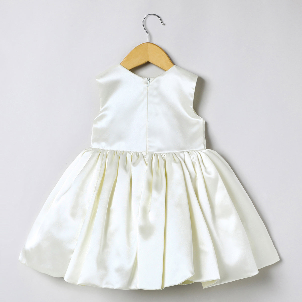 Ivory dress for baby girls features a delicately hand embroidered and scalloped hemline