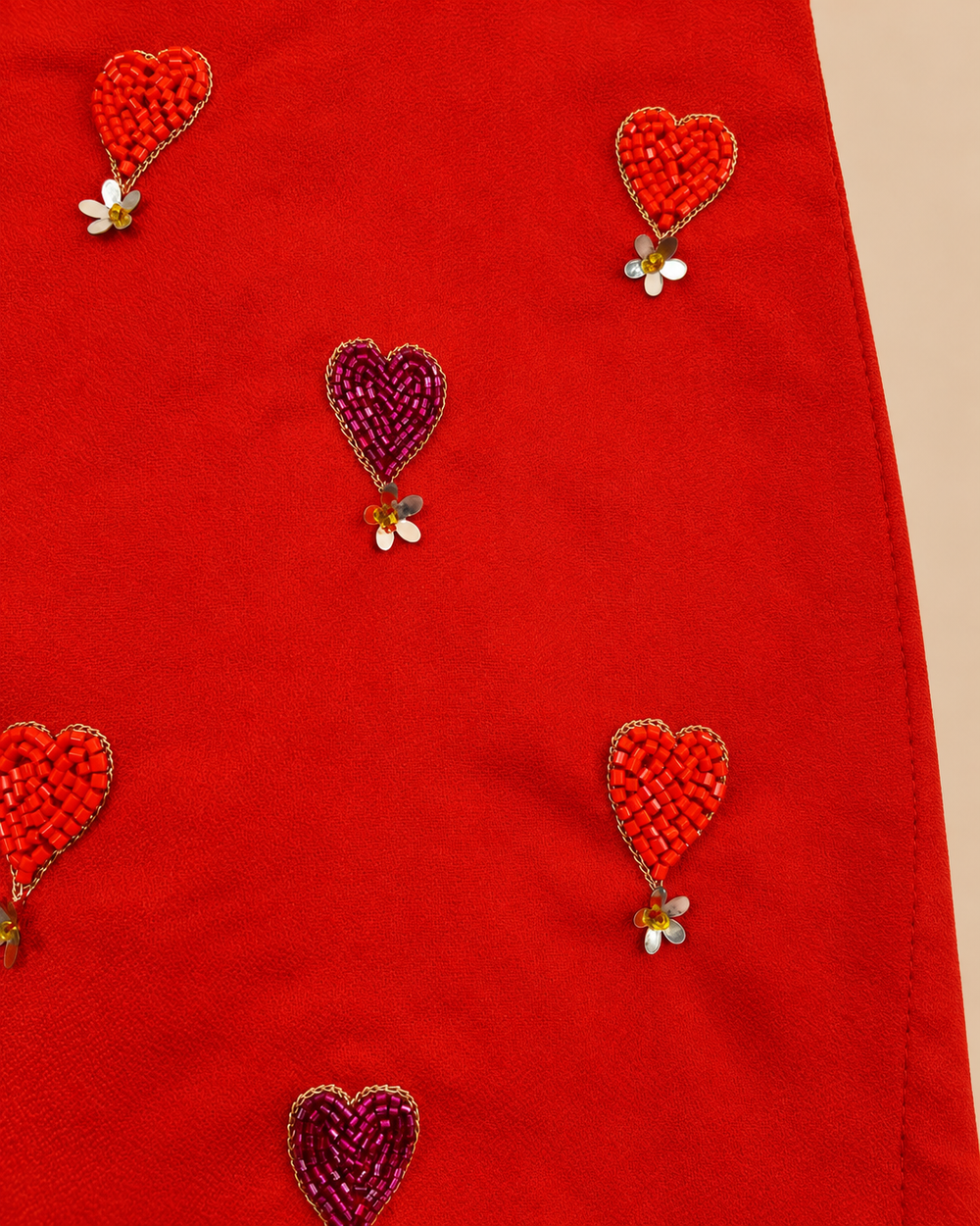 Girls' orange and yellow lehenga set with heart embroidery, pearl embellishments, flared skirt and purple dupatta with golden lace border.